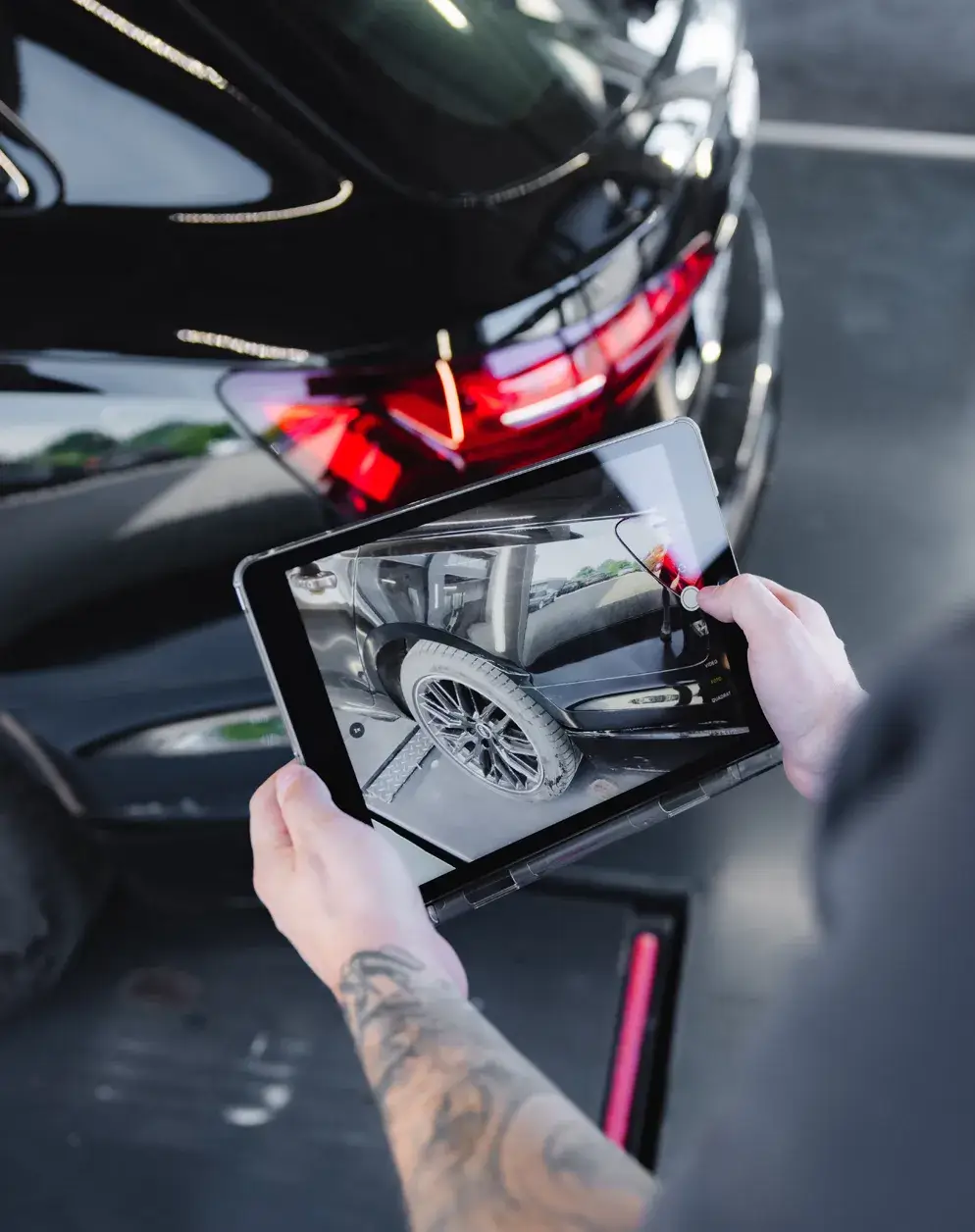 Ein Mitarbeiter analysiert per Tablet den Fahrzeugschaden - moderne Karosseriediagnose bei Karosserie Blanke