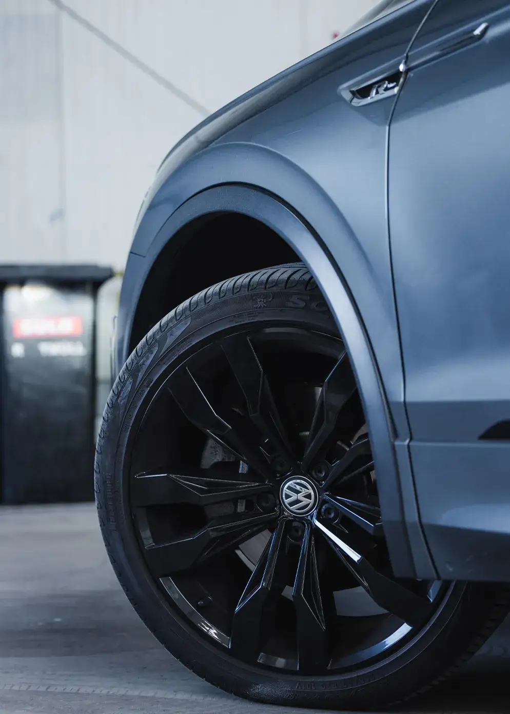 Nahaufnahme eines schwarzen VW-Leichtmetallrads mit perfekt instandgesetztem Radlauf – Karosserie Blanke in Bremerhaven