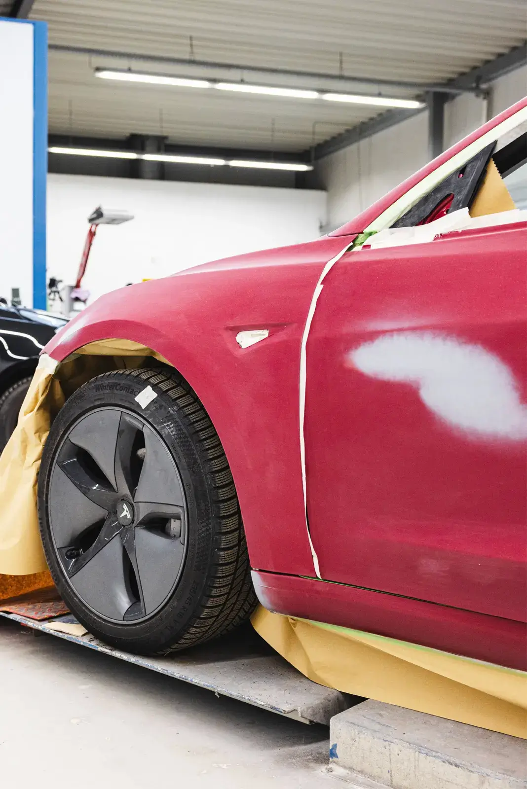 Angeschliffene Fahrzeugseite mit abgeklemmten Bereichen zur Vorbereitung der Lackierung in der Karosseriewerkstatt Blanke