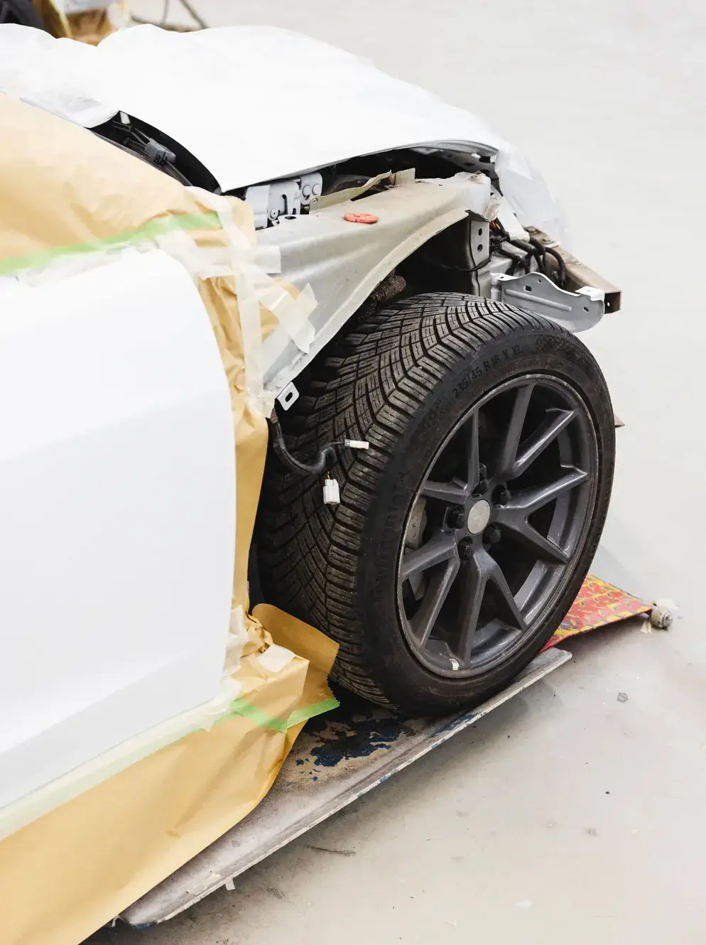 Abgeklebter Radlauf und freigelegte Karosserie vor der Lackierung in der Werkstatt von Karosserie Blanke