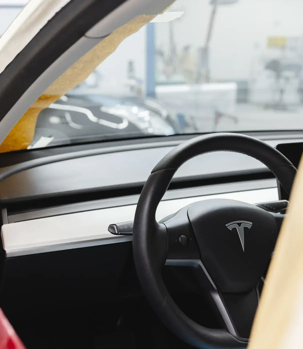 Innenansicht eines Tesla mit Lenkrad und Armaturenbrett während der Reparatur bei Karosserie Blanke